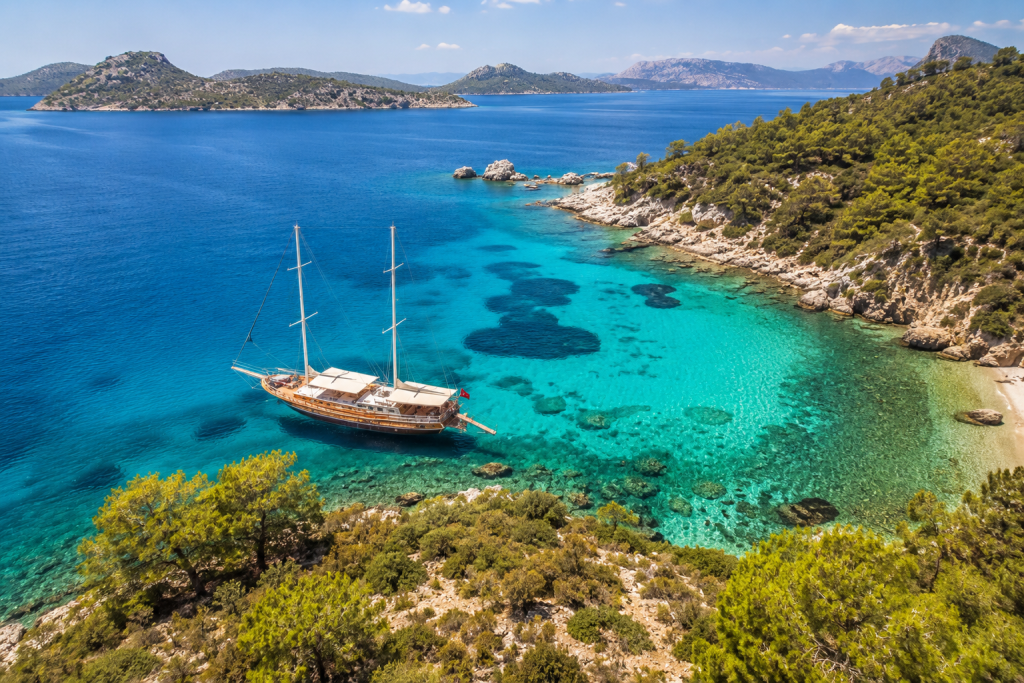 Turquoise Turkish coastline with gulet boat in summer Aegean sea